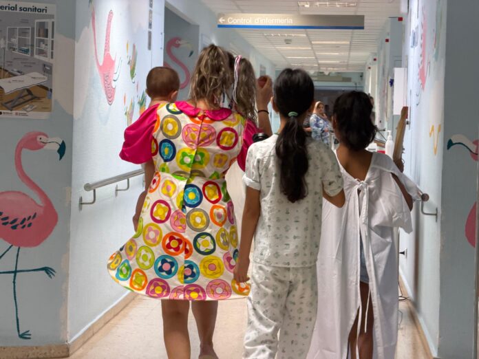 Violeta passeja amb pacients per un dels passadissos de la planta de Pediatria del Verge de la Cinta de Tortosa. / David Benito